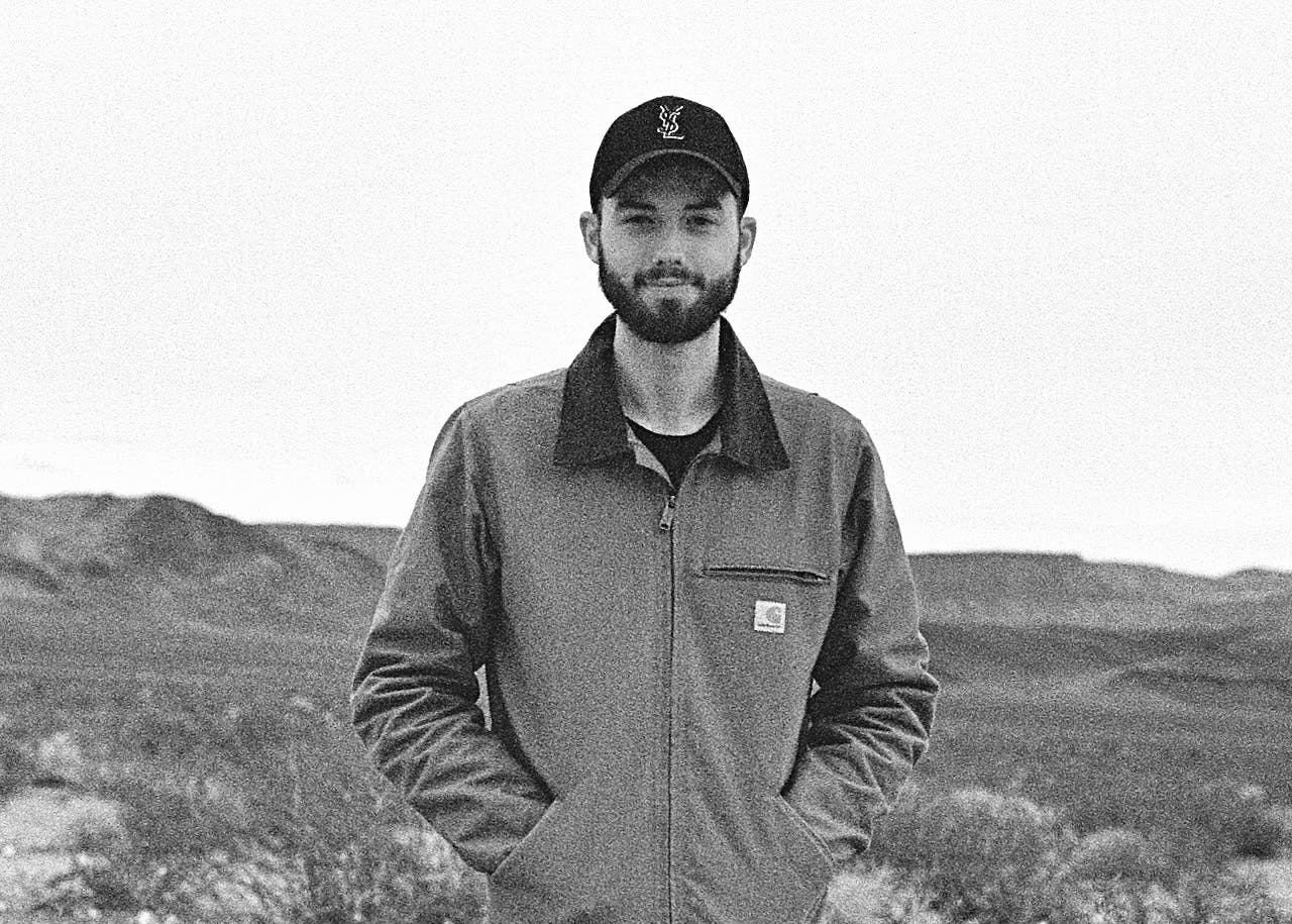 A portrait of Noah in a jacket in the desert